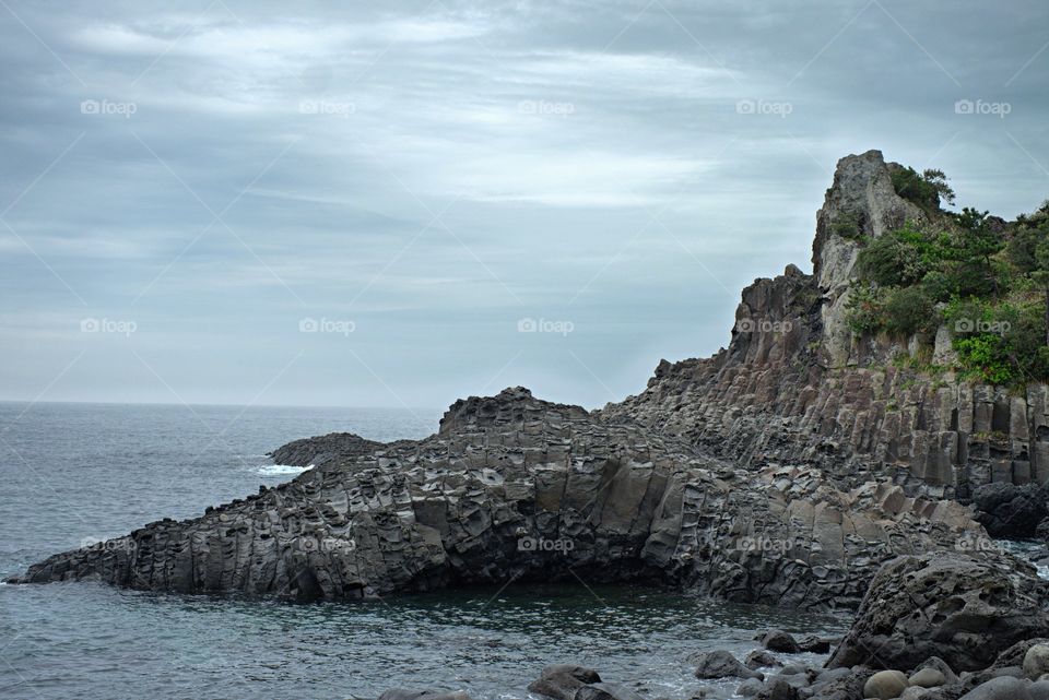 Imposing Jusangjeolli stone pillars are piled up along the coast of Jeju Island.