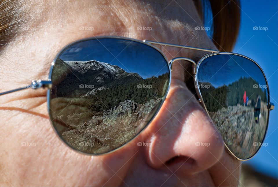 Snowy mountain reflected on sunglasses 