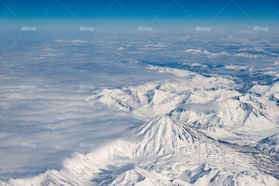 snowy Kamchatka volcanoes from a bird's flight