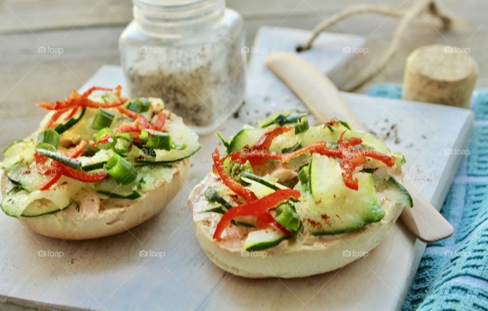 Salmon spread with thinly sliced cucumber, red pepper, and green onion on toasted bagel 🥯