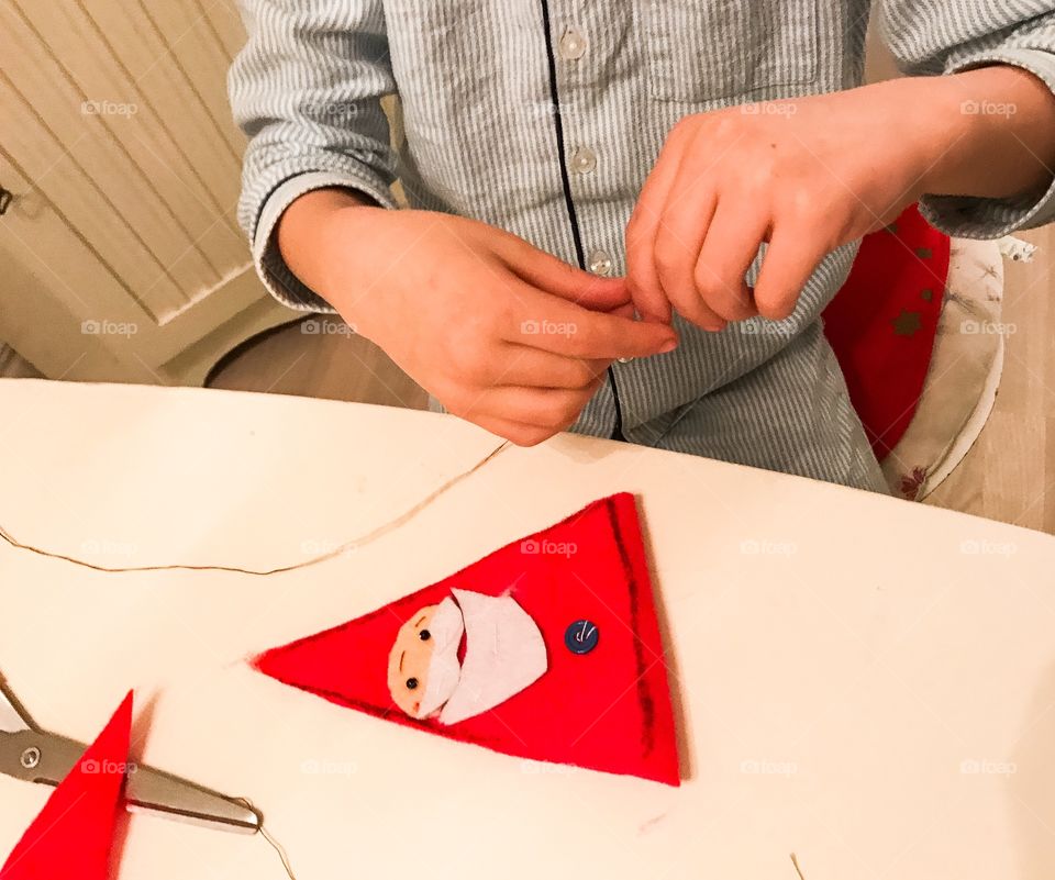 Kid sewing a Santa Claus 