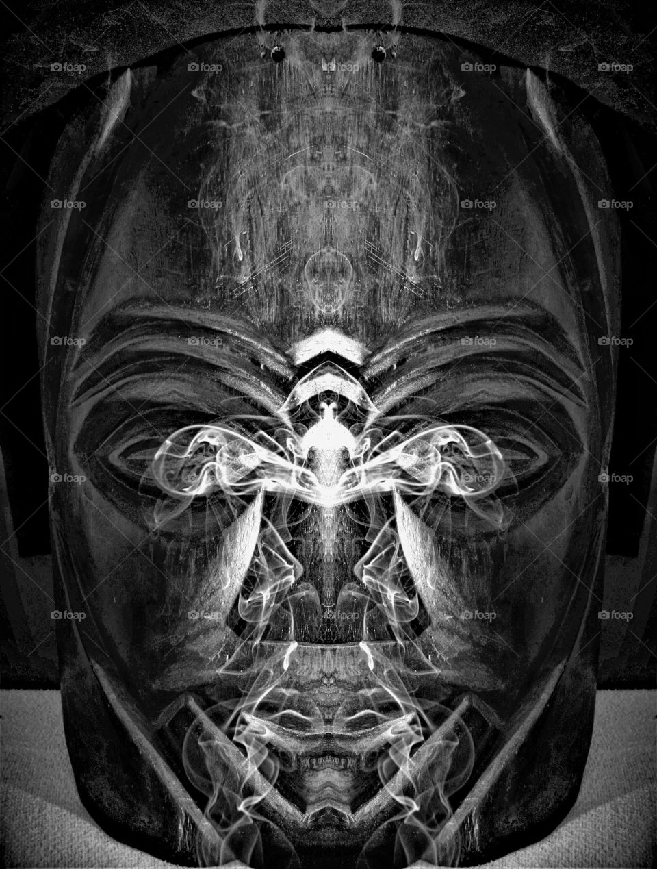 wooden tribal mask with smoke black and white close up photograph
