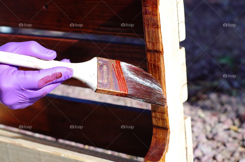 Applying wood stain to a homemade wine rack.