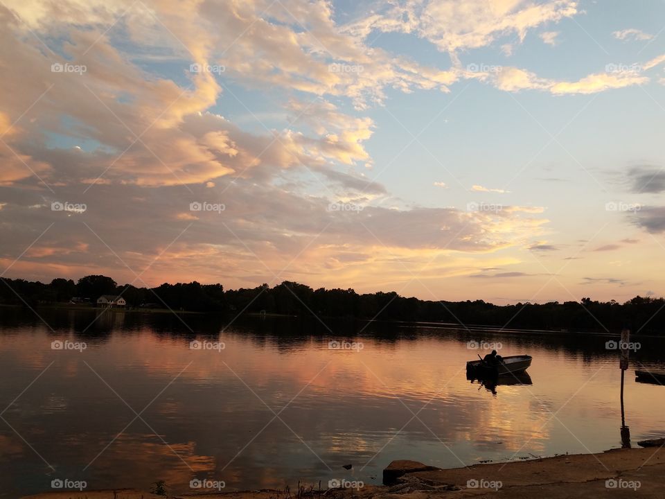 Man fishing with dog in boat