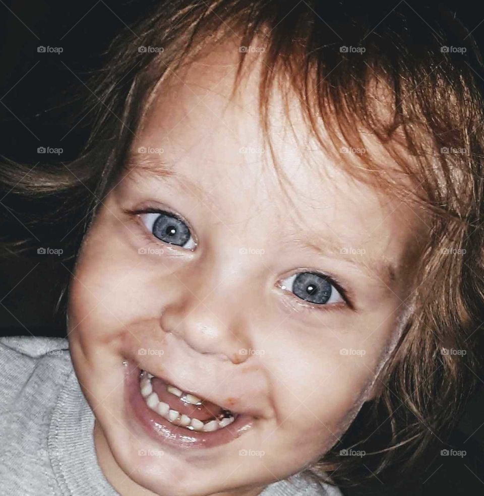 Little boy laughing with big blue eyes