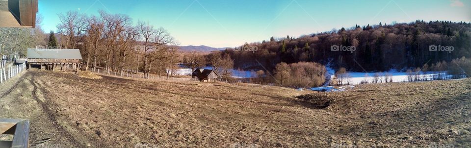 Panoramic photo of a mountain landscape in winter with frozen lake