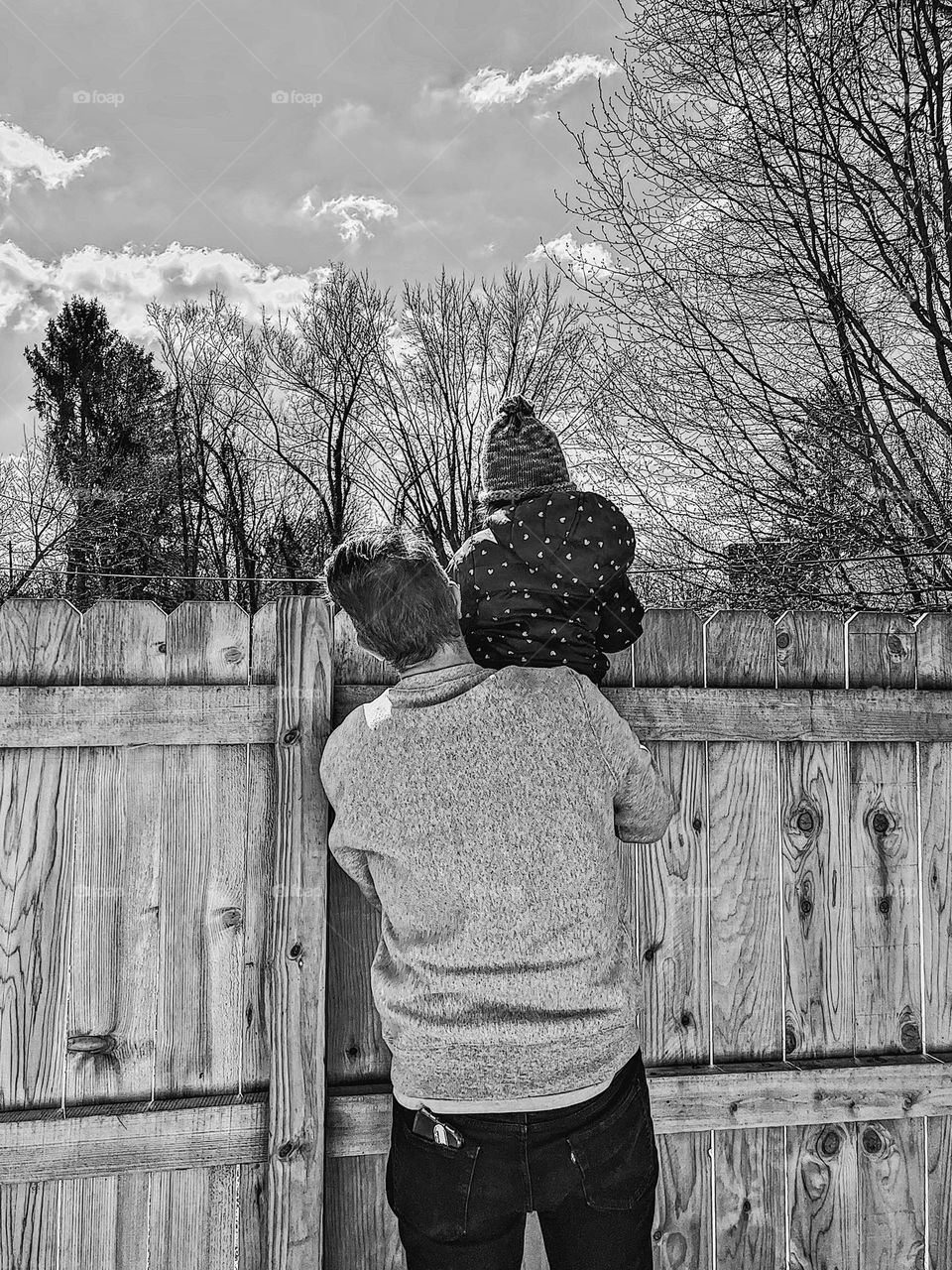 Father and child look over fence, father holds child on shoulder, cute portrait of father, girl dad with daughter 