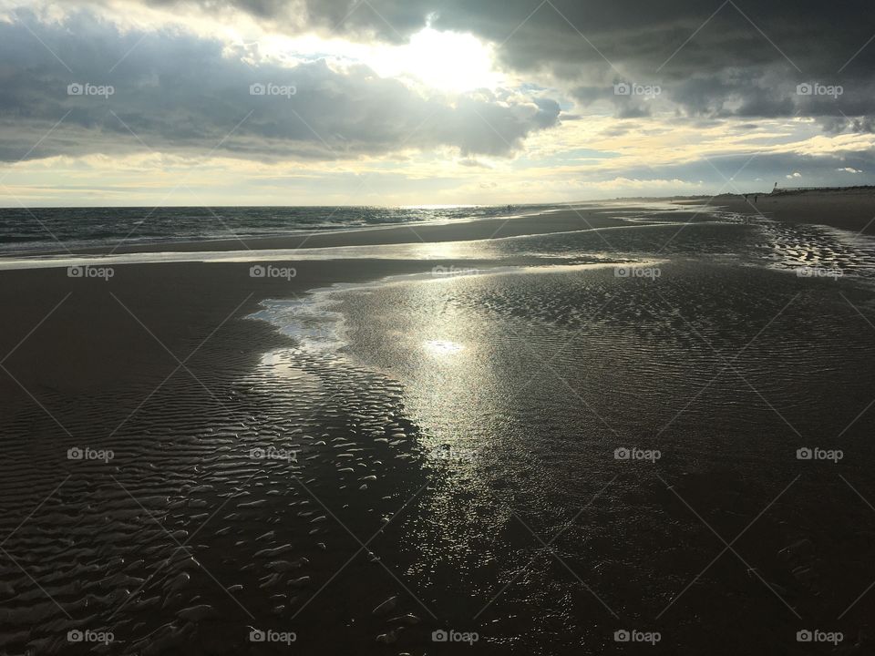 Evening sun among clouds on beach
