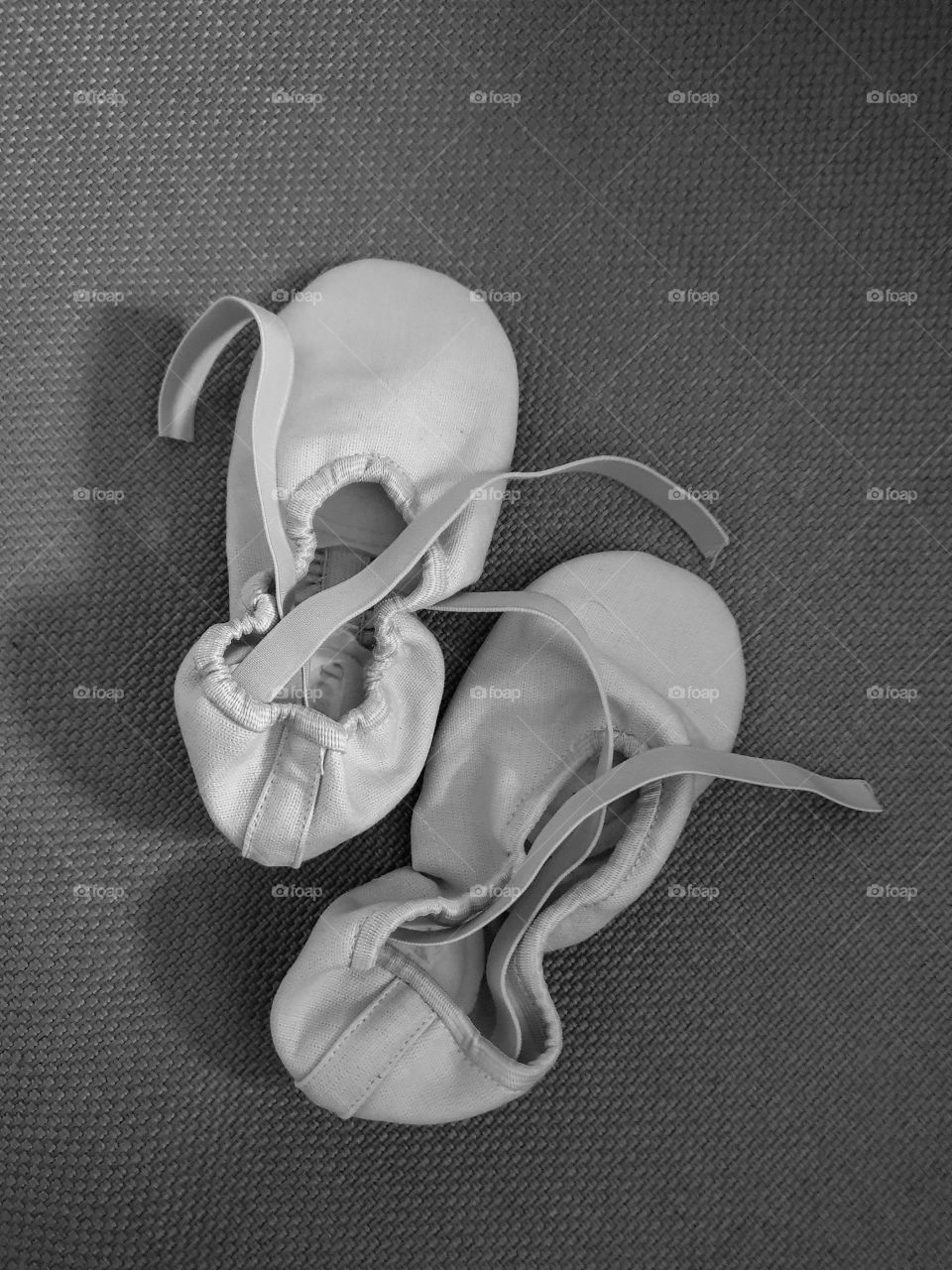 New white ballet slippers with unfinished ribbons on a textured background. Pointe shoes