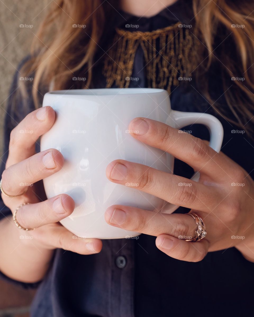 Delicate hands holding a strong coffee. 