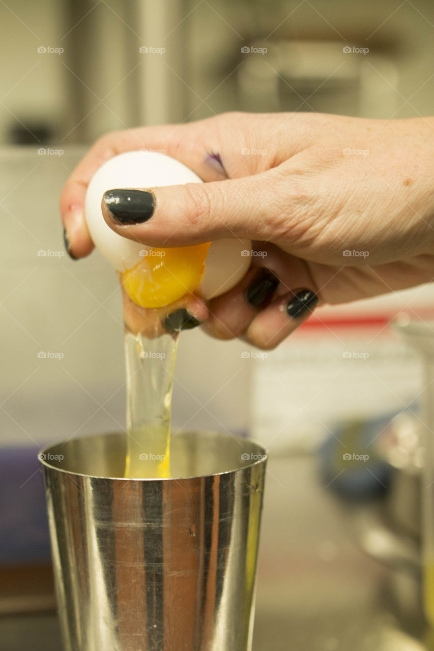 Egg being cracked for cocktail