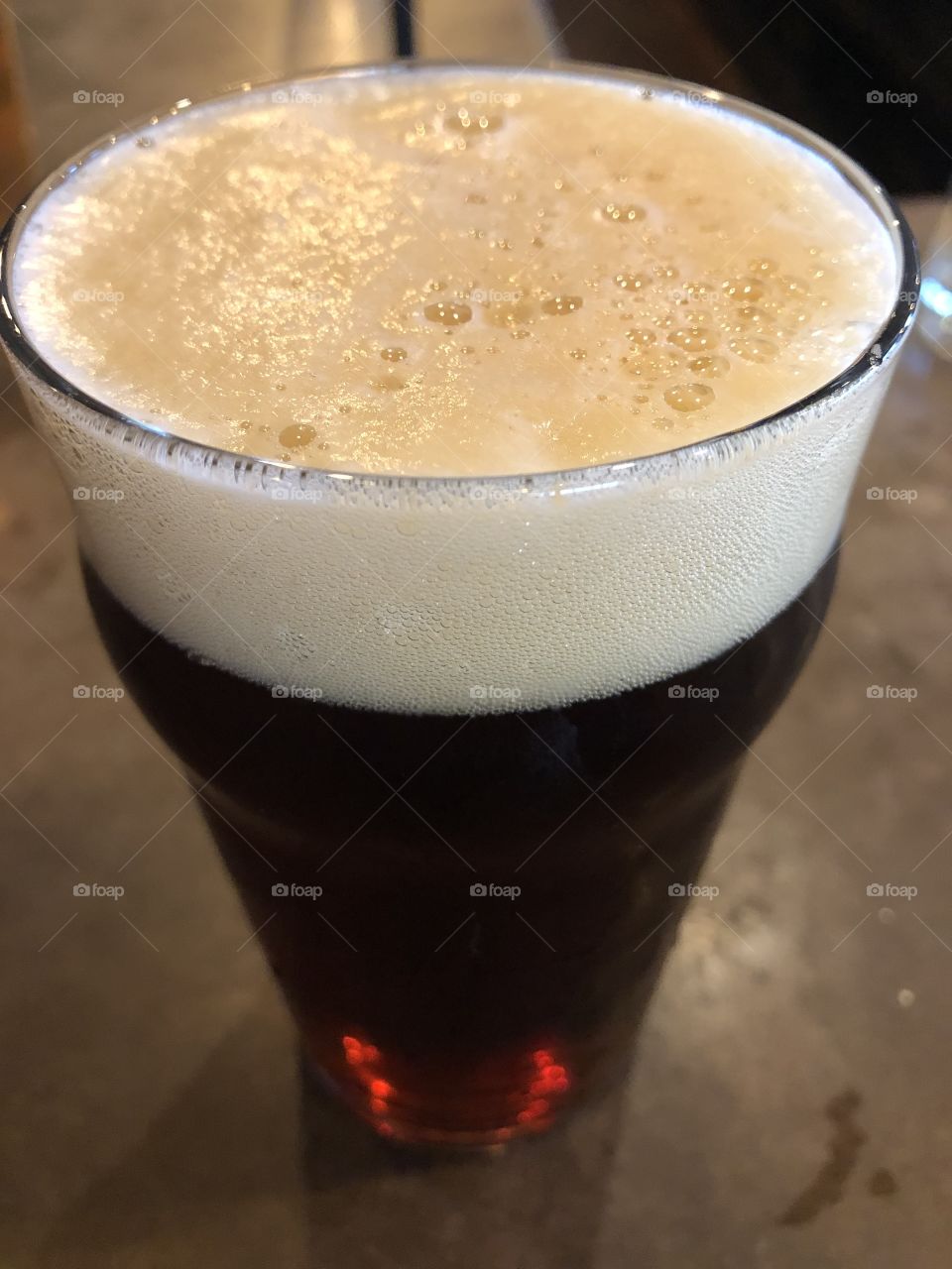 Reddish colored beer with foam