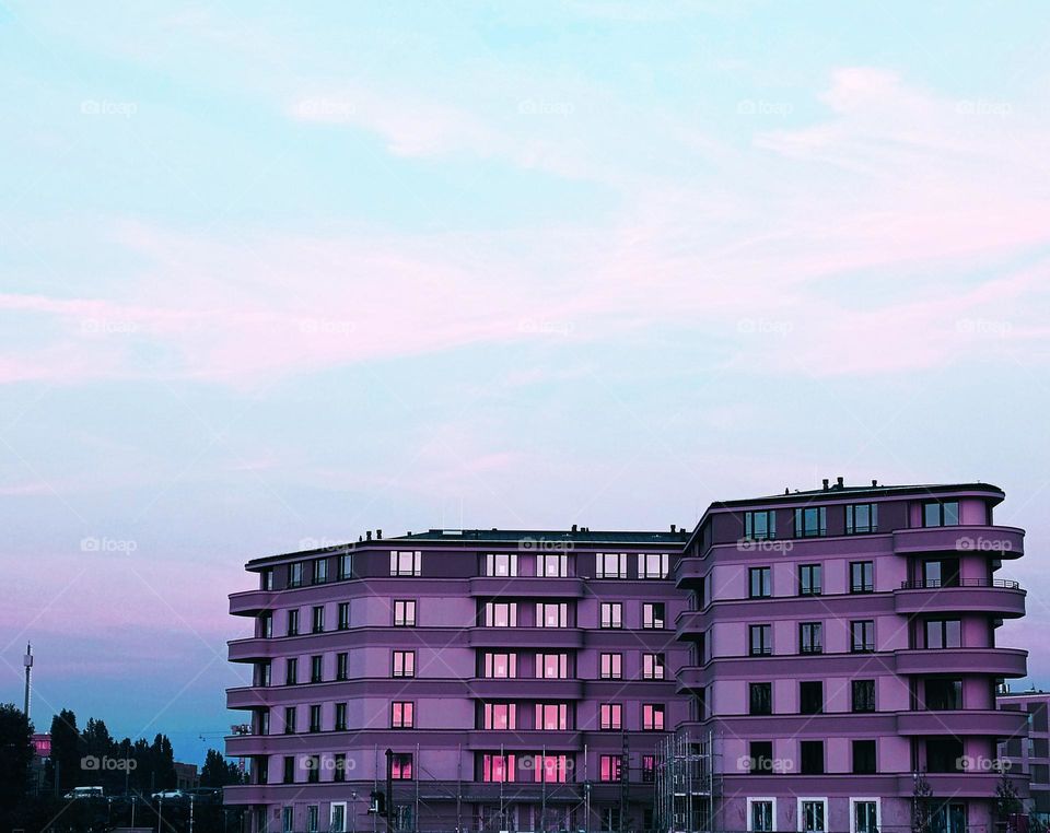 Isolated building is reflecting the sunset in the windows,every floor in an other colour of light