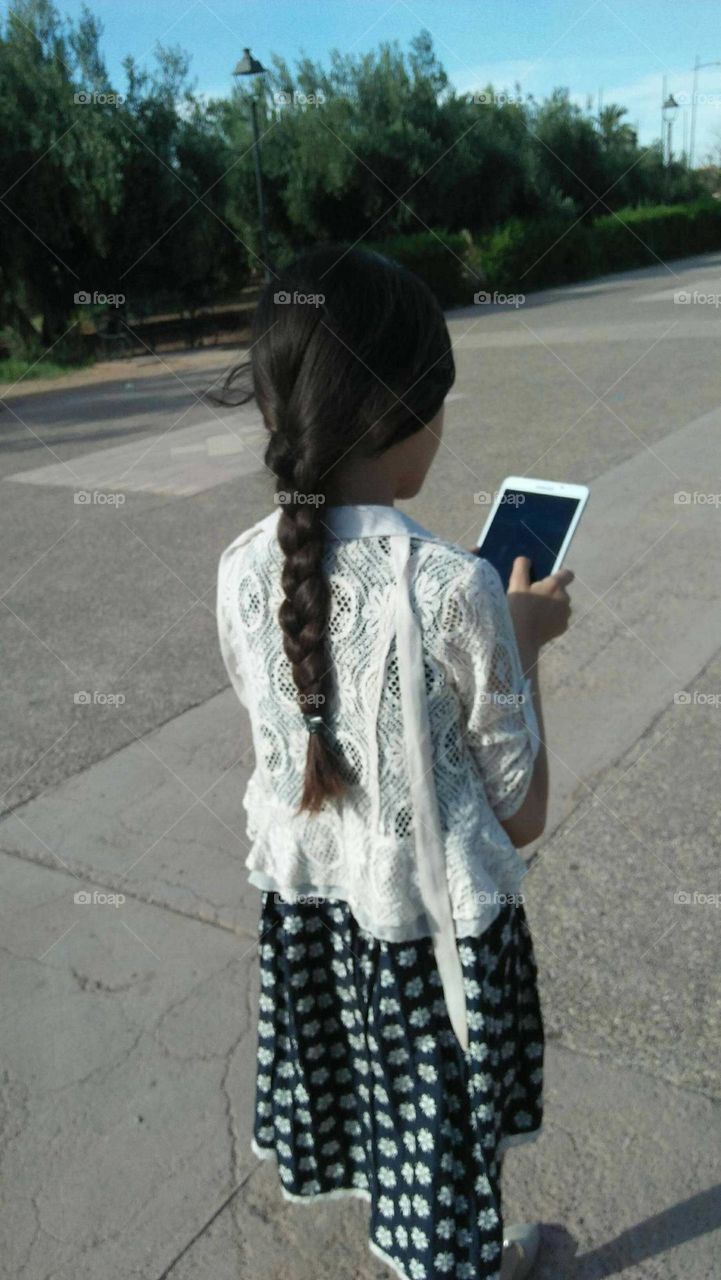 A child holding its smartphone