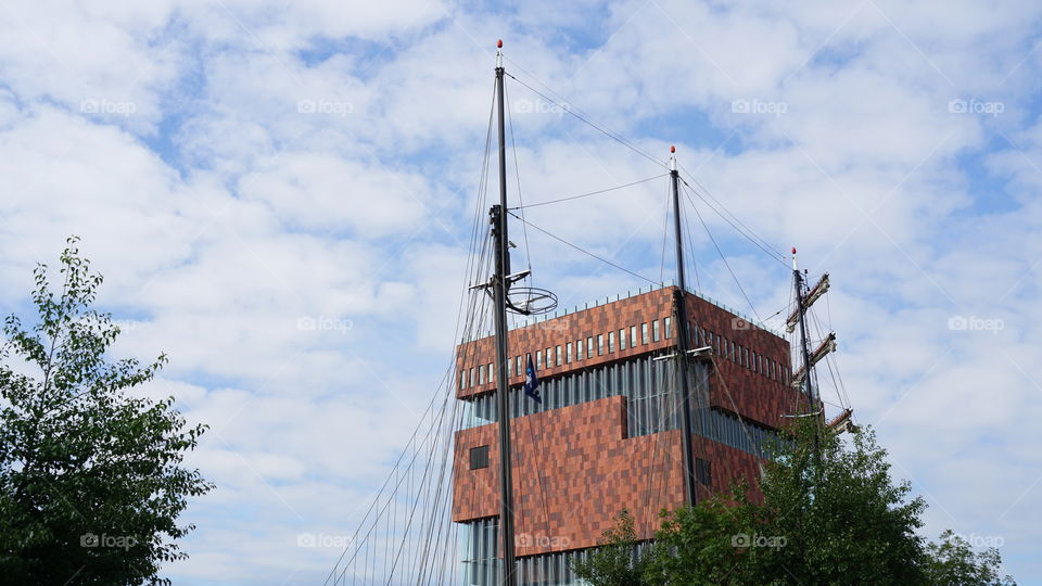 Modern building and mast of a ship at the old port of Antwerp.