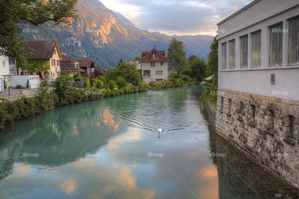 Reflection of mountain and building on canal, Switzerland