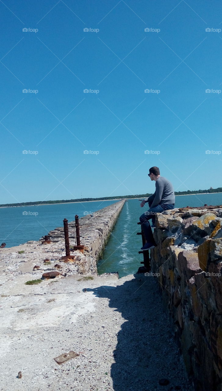 man sitting on a ruins cliff