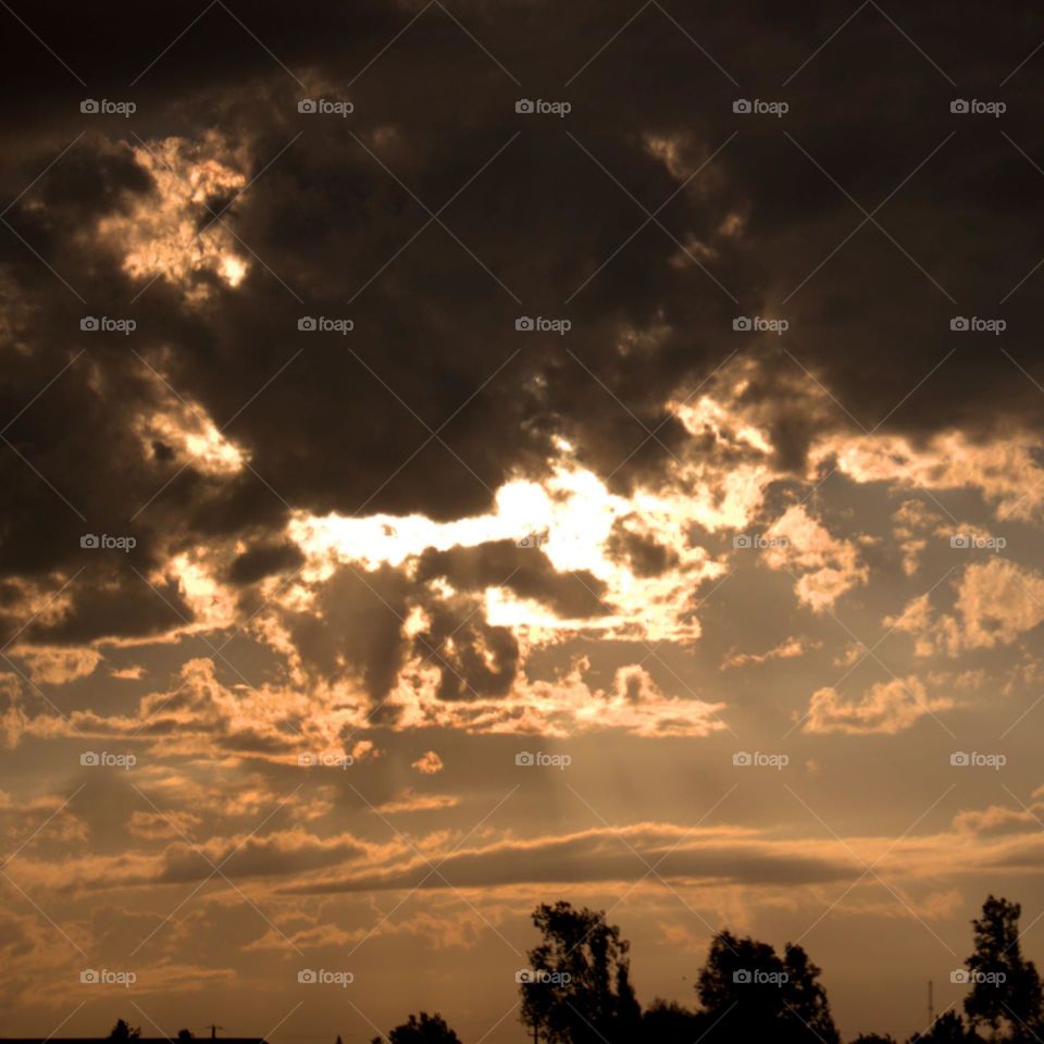 The sun covered by clouds at the end of a day.