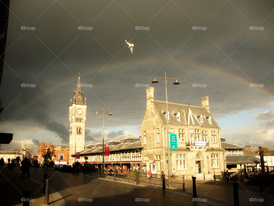 Daytime that thinks it’s night .. dark rain clouds and a rainbow and a flying pigeon to top it off 