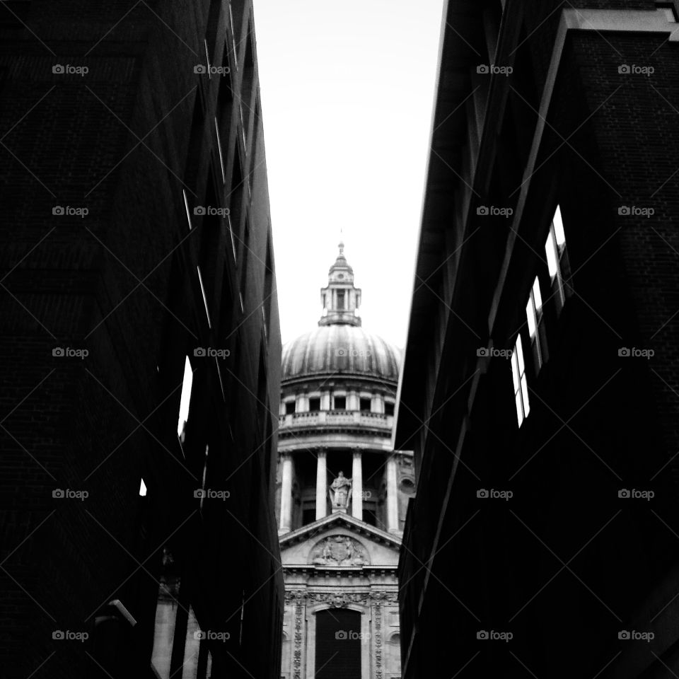 saint Paul's cathedral through an ally in black and white