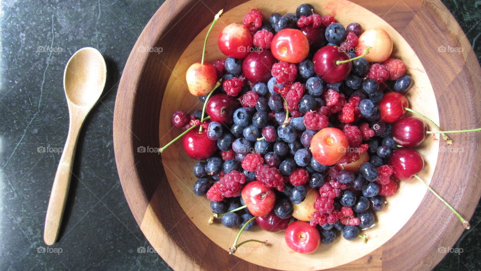 Abundance of berries in wooden bowl