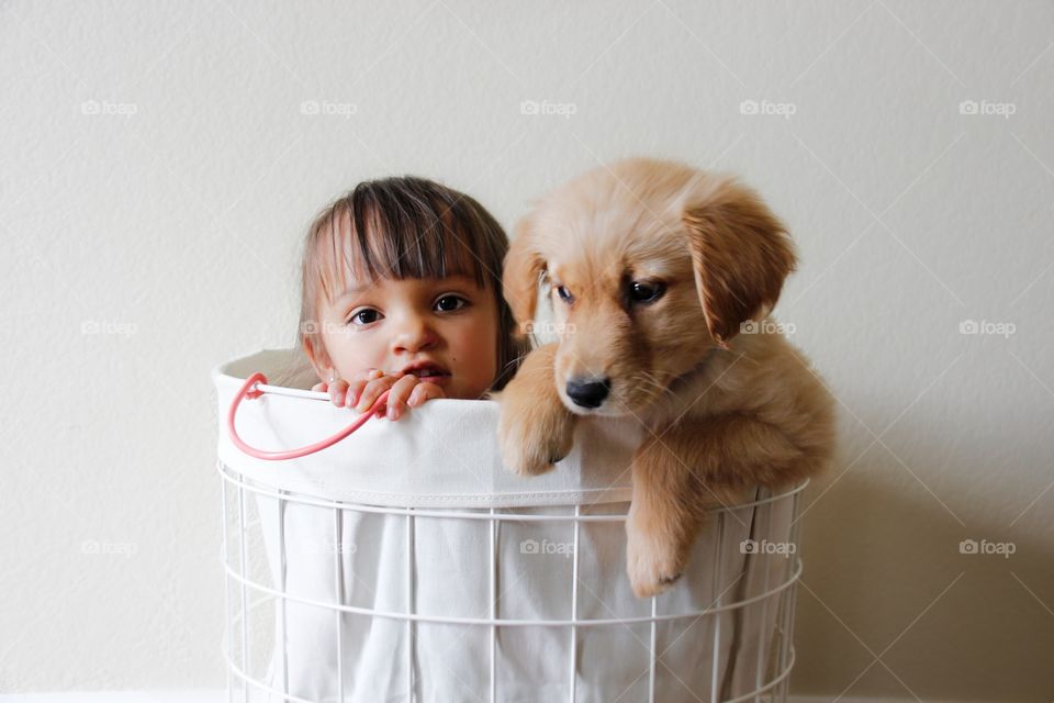 Girl standing in basket with dog