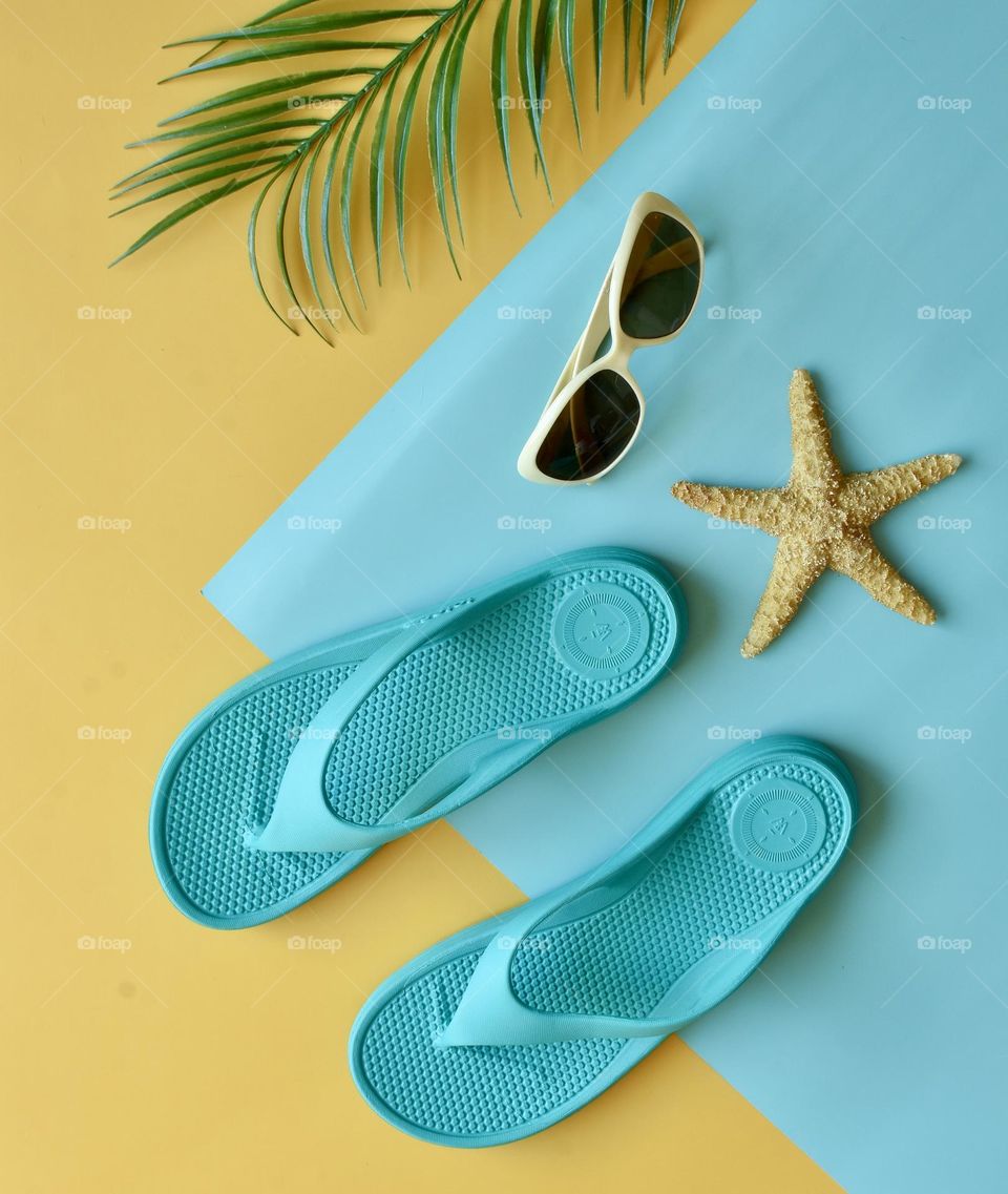 Summer still life flat lay with flip flops, sunglasses and starfish 