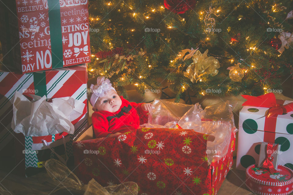 Close-up of a baby near illuminated christmas tree