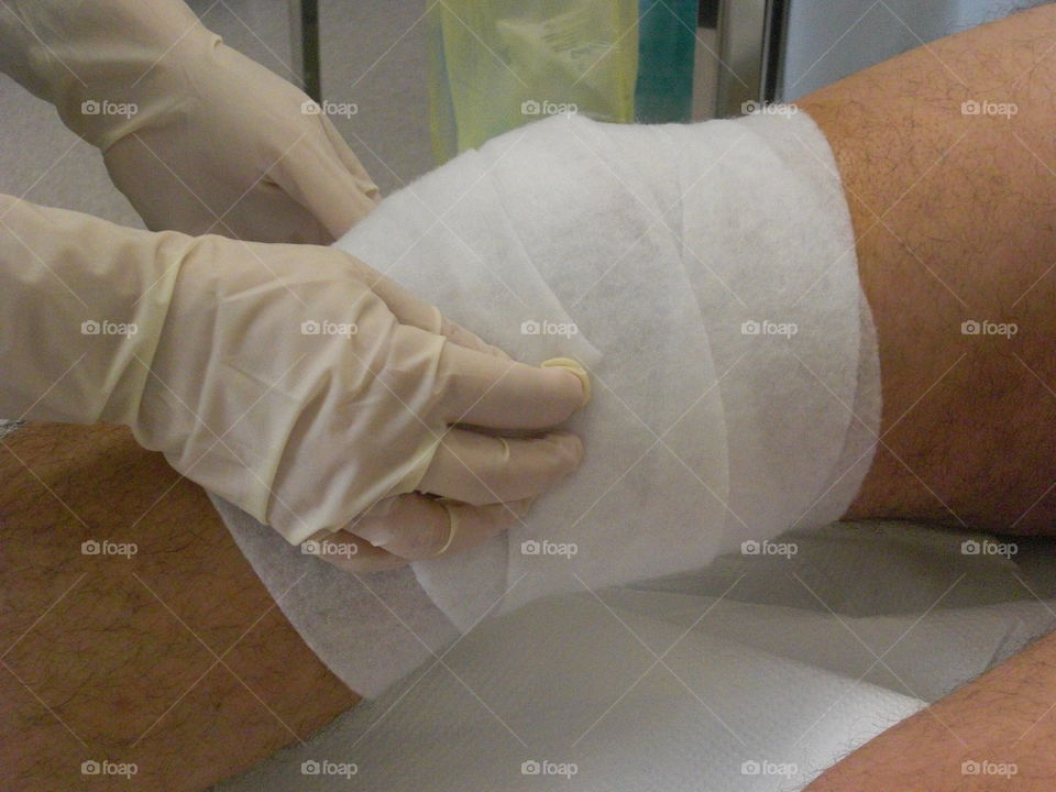 Healthcare worker applying a bandage to the knee