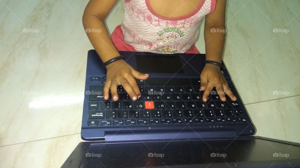 child operating laptop playing games