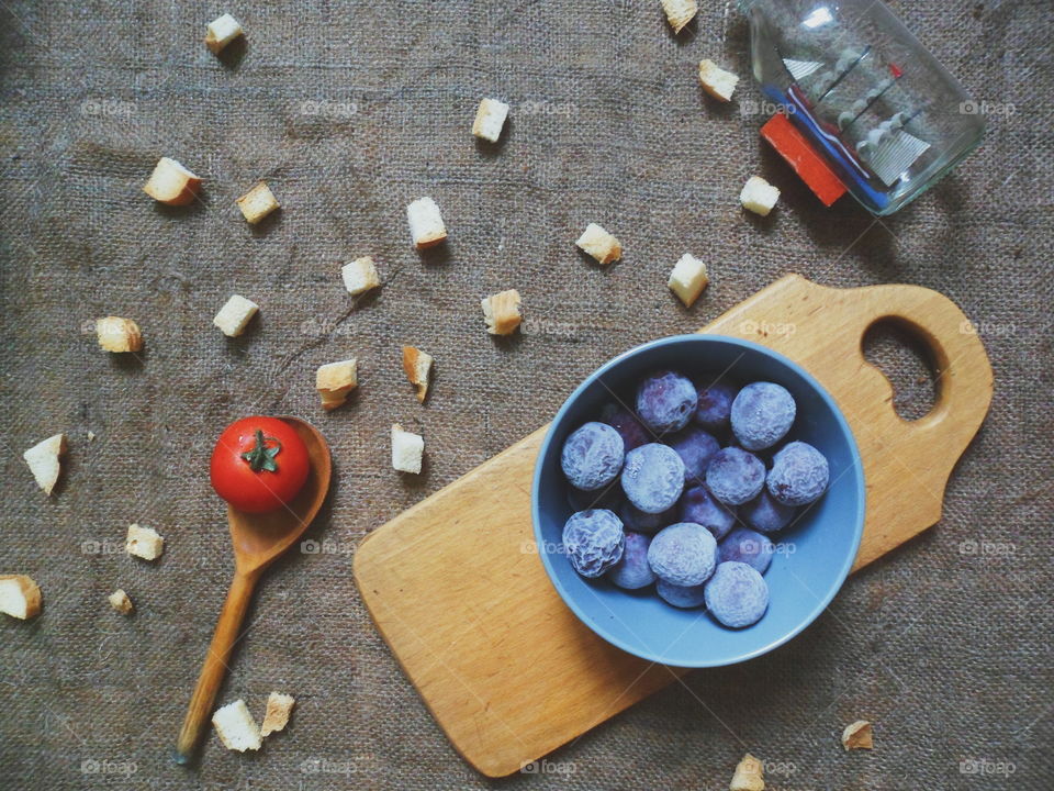 frozen plums, tomatoes white crackers on the table