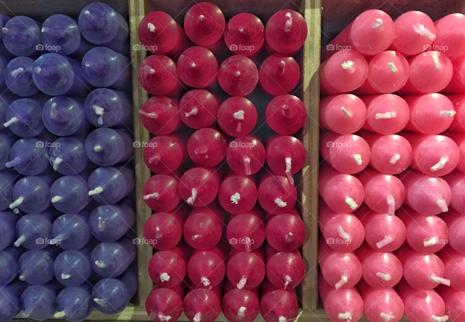 Violet, cherry-red and pink candles in a box