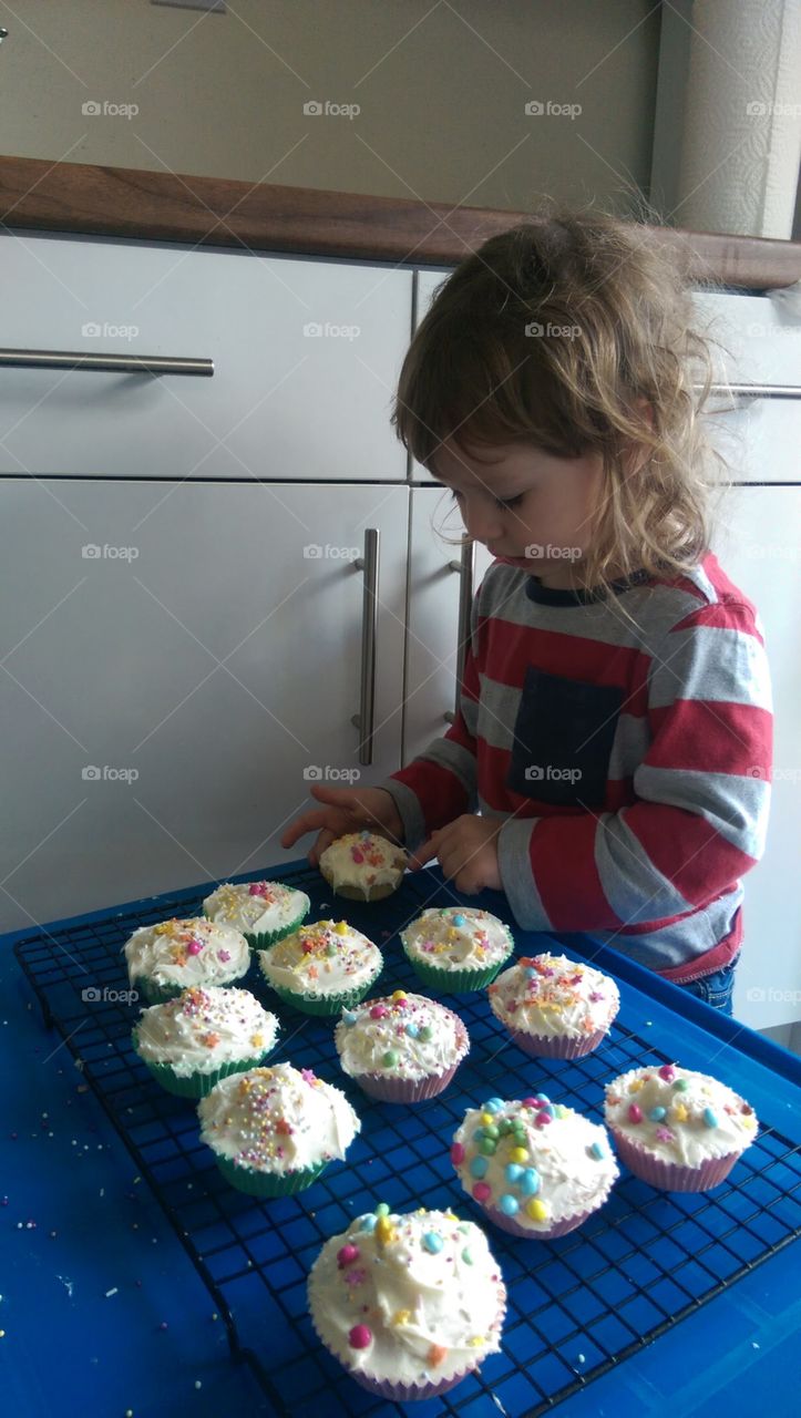 child decorating home made cupcakes