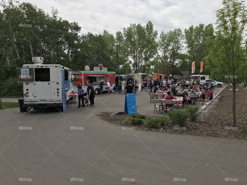 Lots of people are having lunch at the food truck festival.