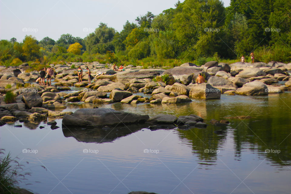 People chilling on the river’s stones