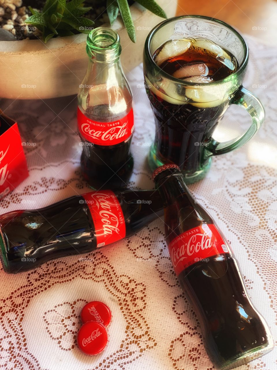 Three Coca Cola bottles on a table 