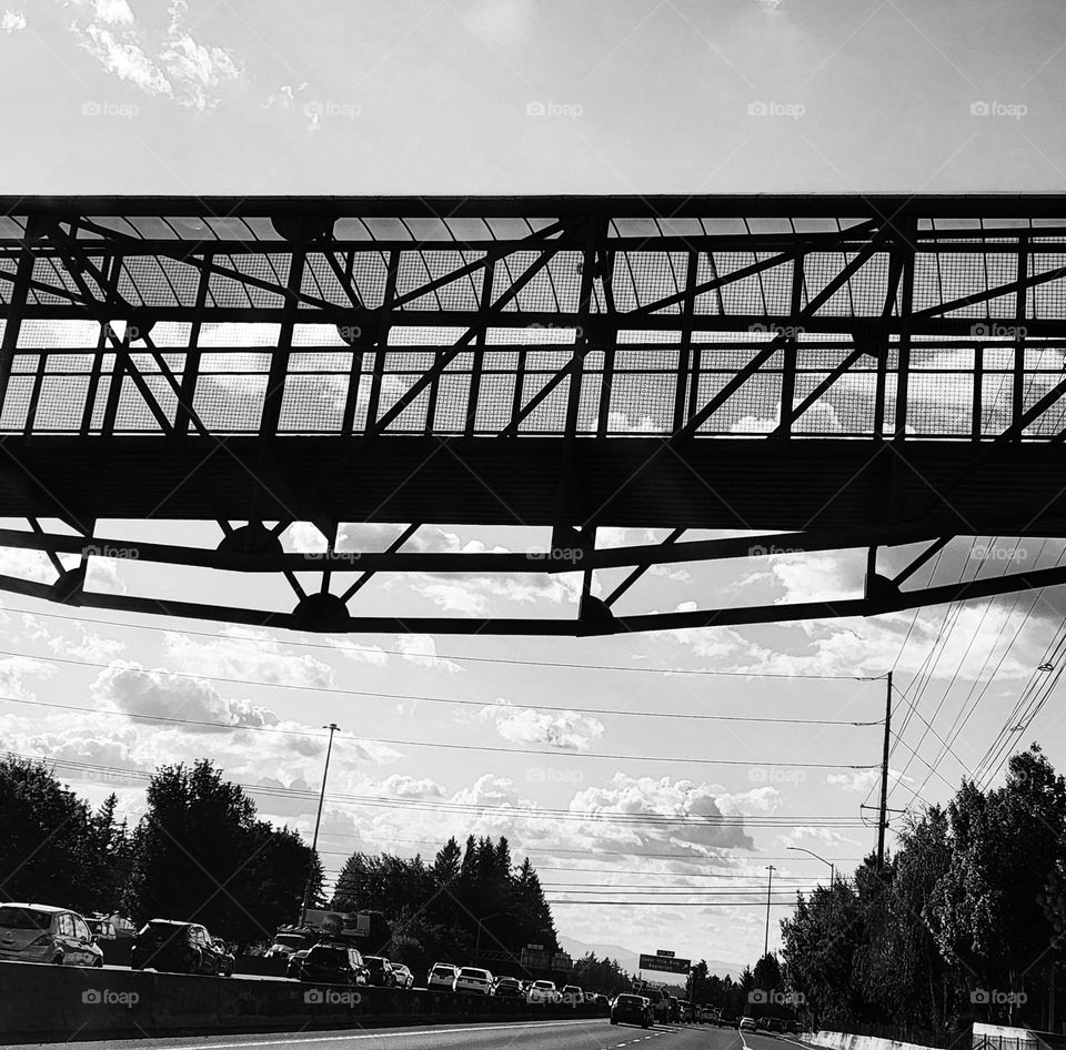 black and white view of a dark walking bridge over traffic during late afternoon in Oregon