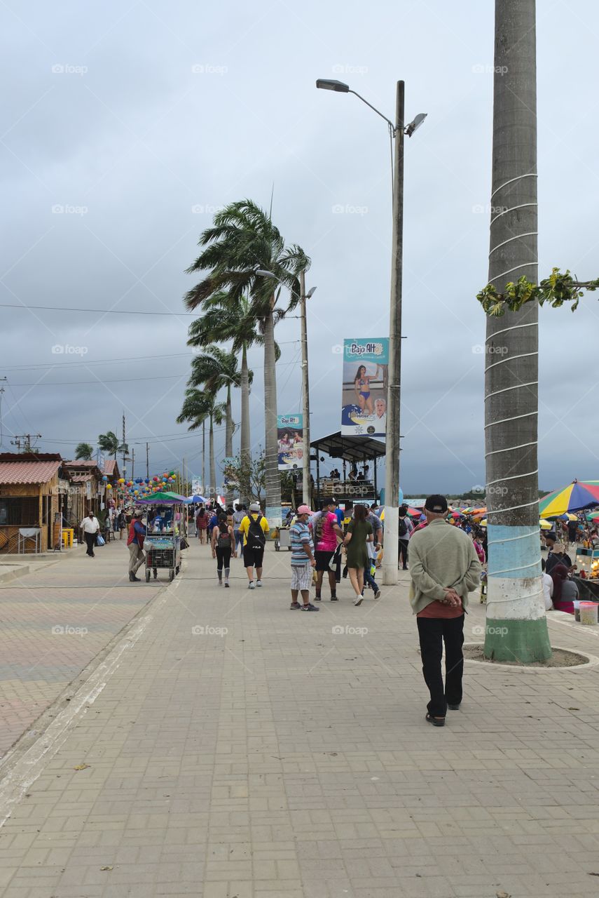 People strolling along the beach on a cloudy day