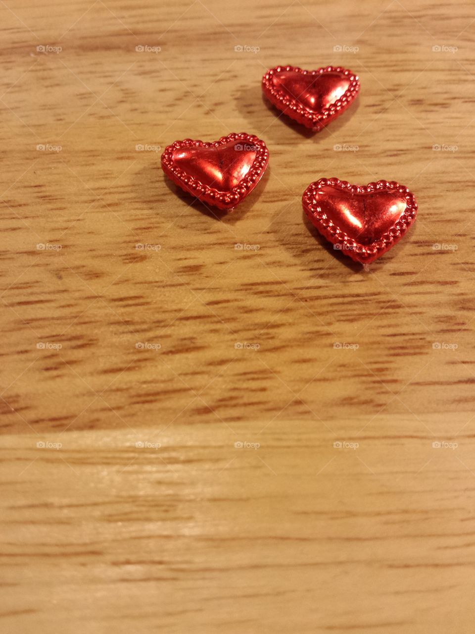 shiny red hearts on wooden background