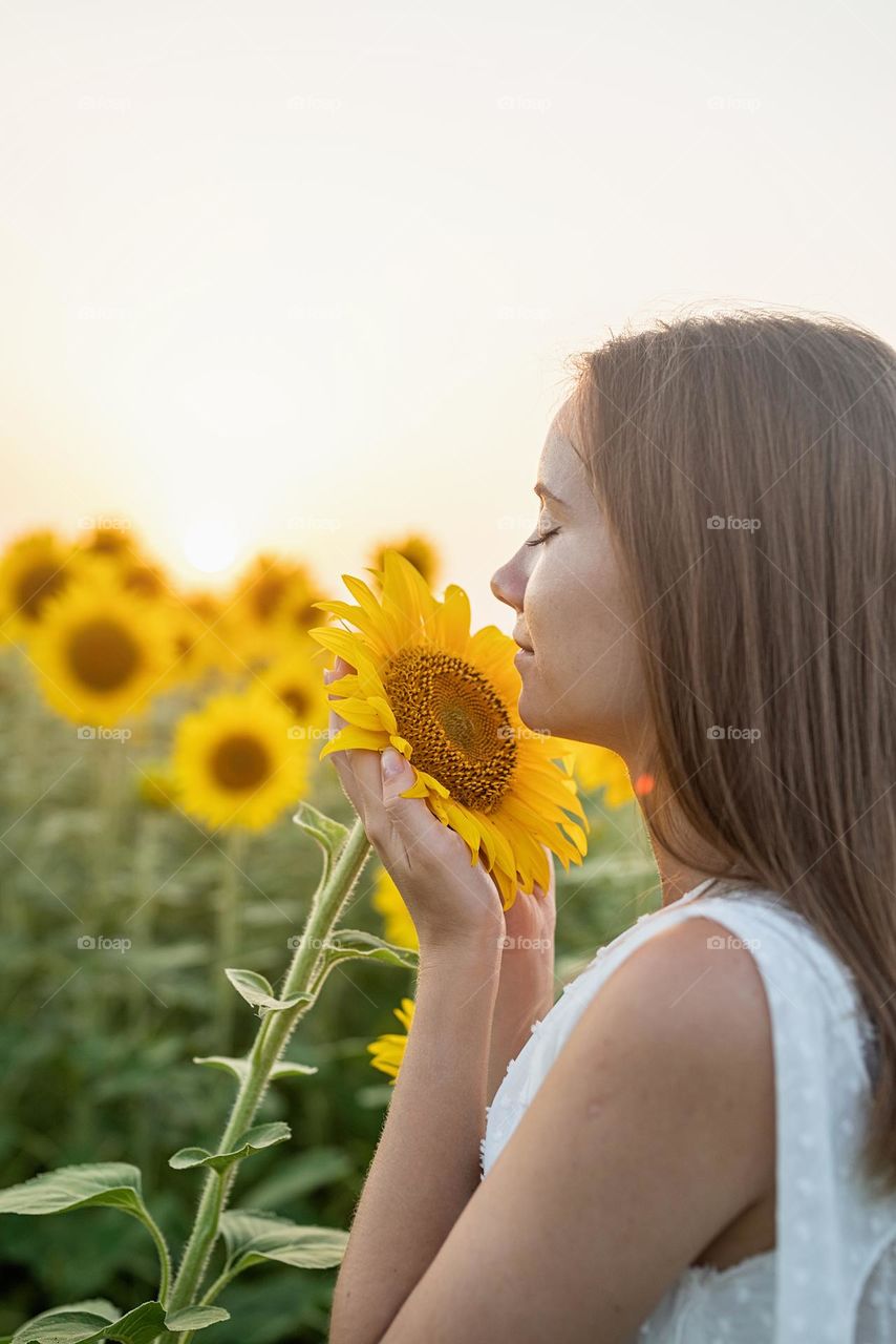 woman smelling sunflowers