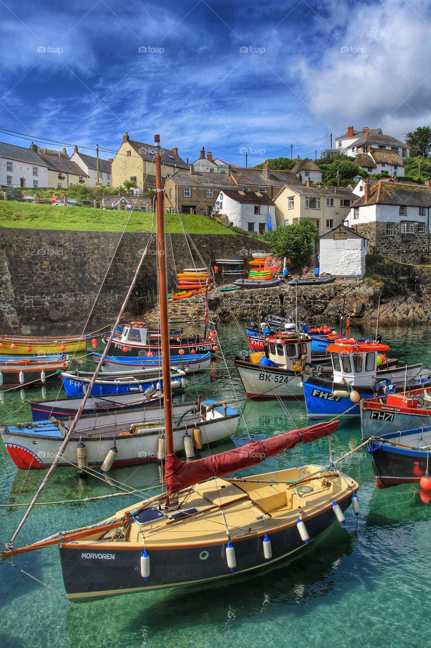 A busy Cornish harbour packed full of fishing boats and leisure craft on a beautiful sunny day.