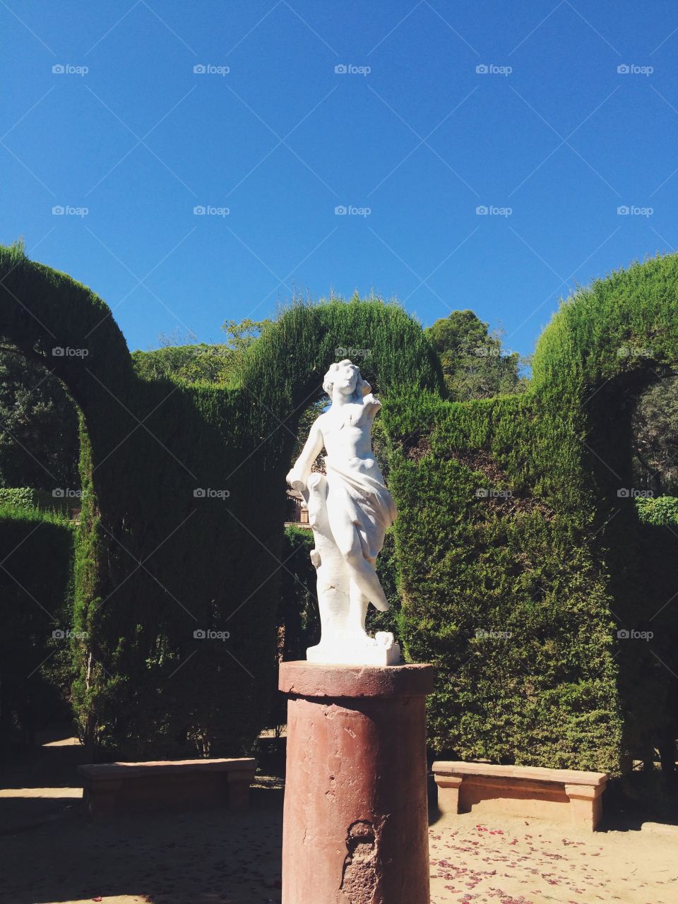 Sunny day in a garden with a sculpture in Barcelona Spain 