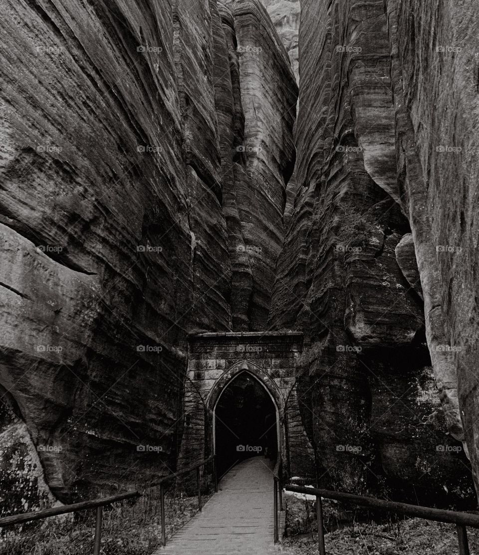 Dark gothic portal in the Czech Republic, mountains. Stone and rock structures, a path with no people, nature in black and white 