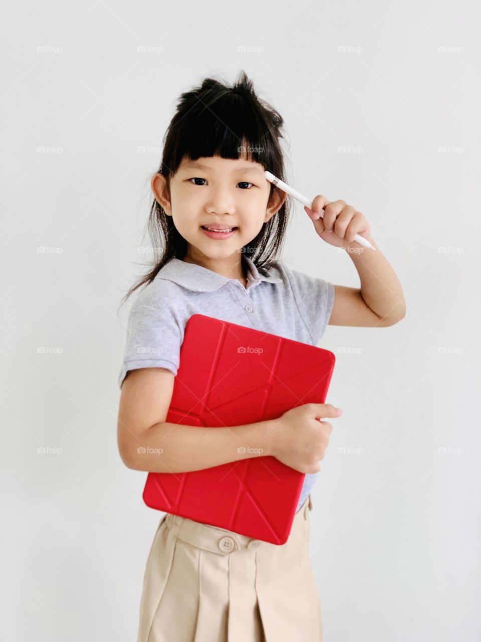 A little girl holding a tablet ready to go to school.  concept back to school.