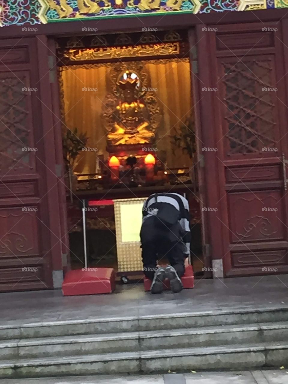 A man praying to Buddha. Buddha Shrine. Ngong Ping Village, Po Lin Monastery, Lantau Island, Hong Kong. 