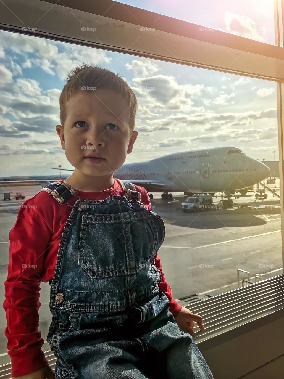 Boy looking at the window in the airport 