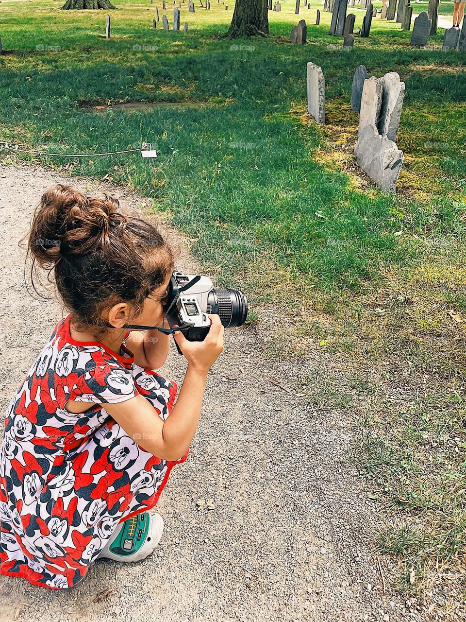 Little girl photographs graveyard, toddler girl uses Canon camera, taking photos with kids 