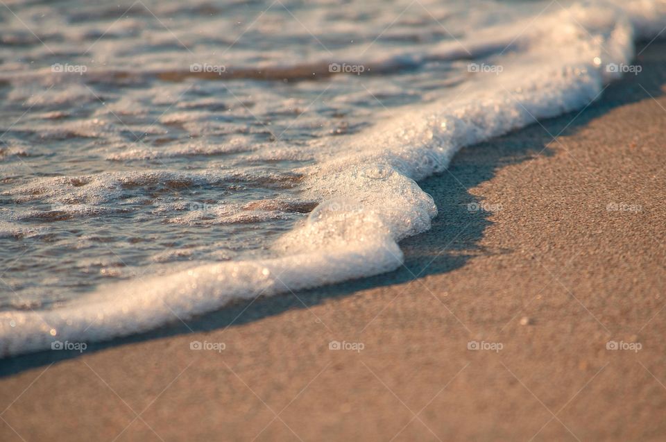 Waves roll on to the beach as the sun sets in Hollywood Beach, Florida. 