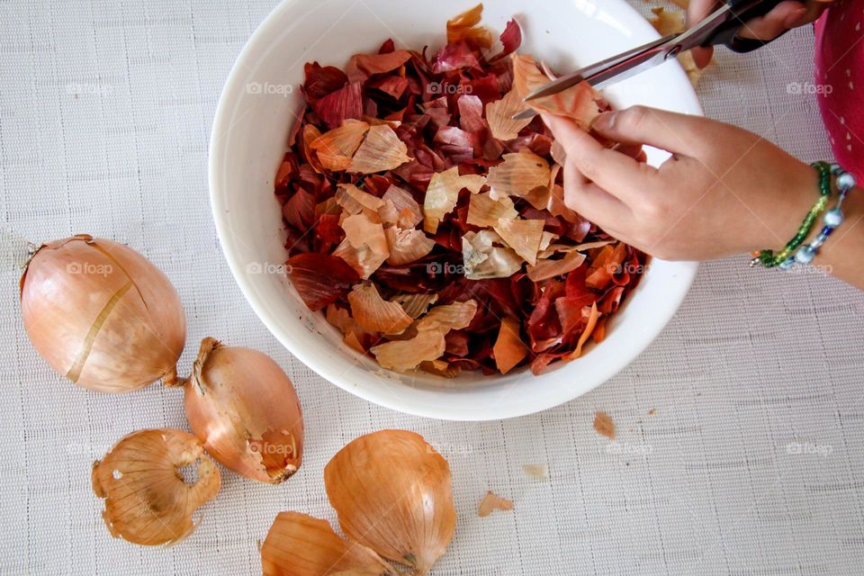 Child is coloring eggs using onion shells