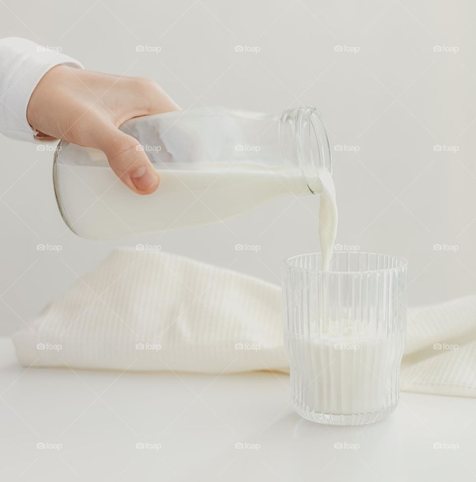 Person poured milk in the glasse.